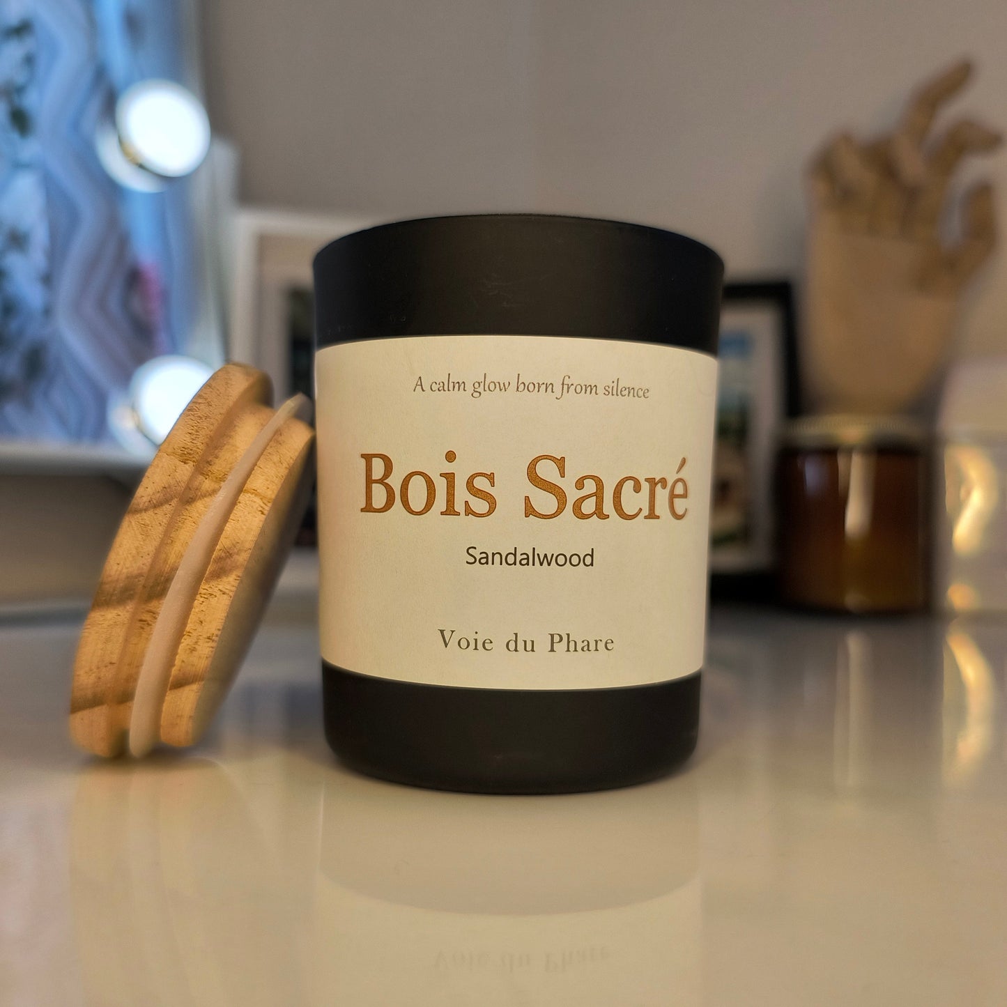 Candle labeled 'Bois Sacre' with a blurred background