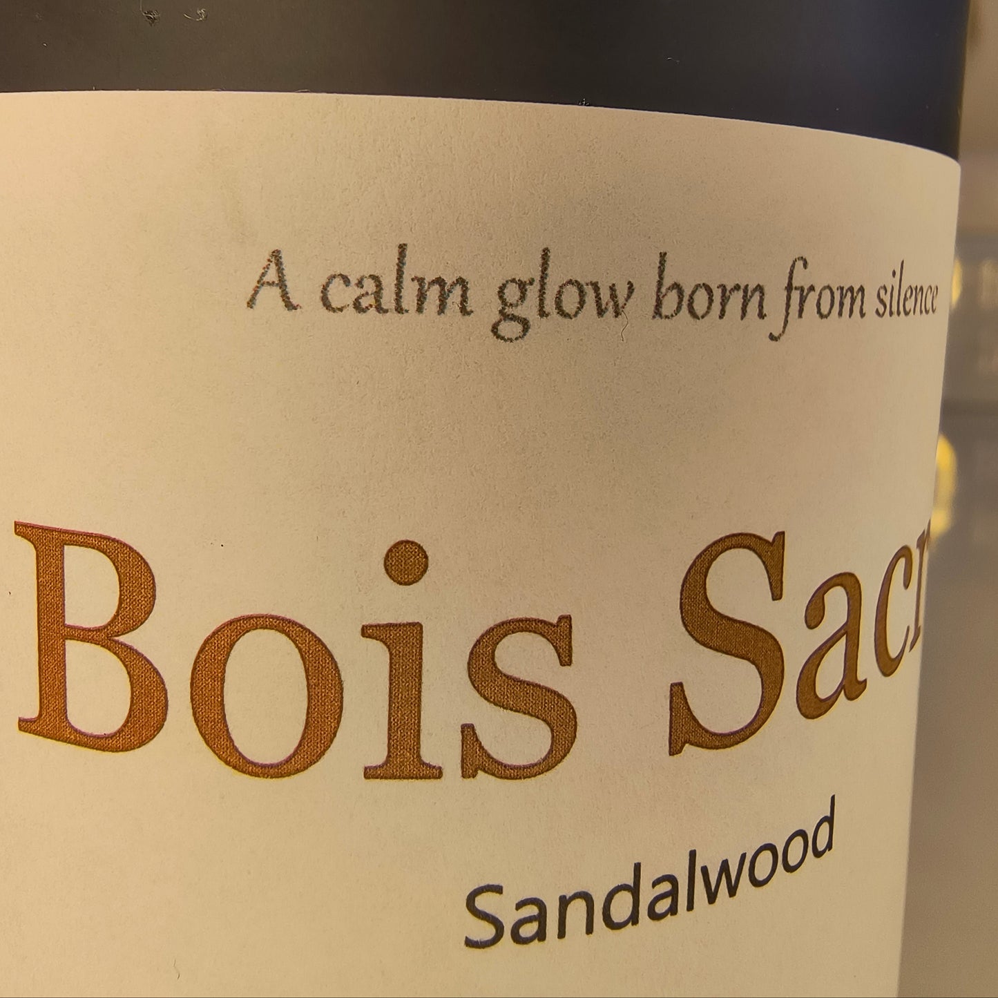 Candle 'Bois Sacre' sandalwood label on a dark background