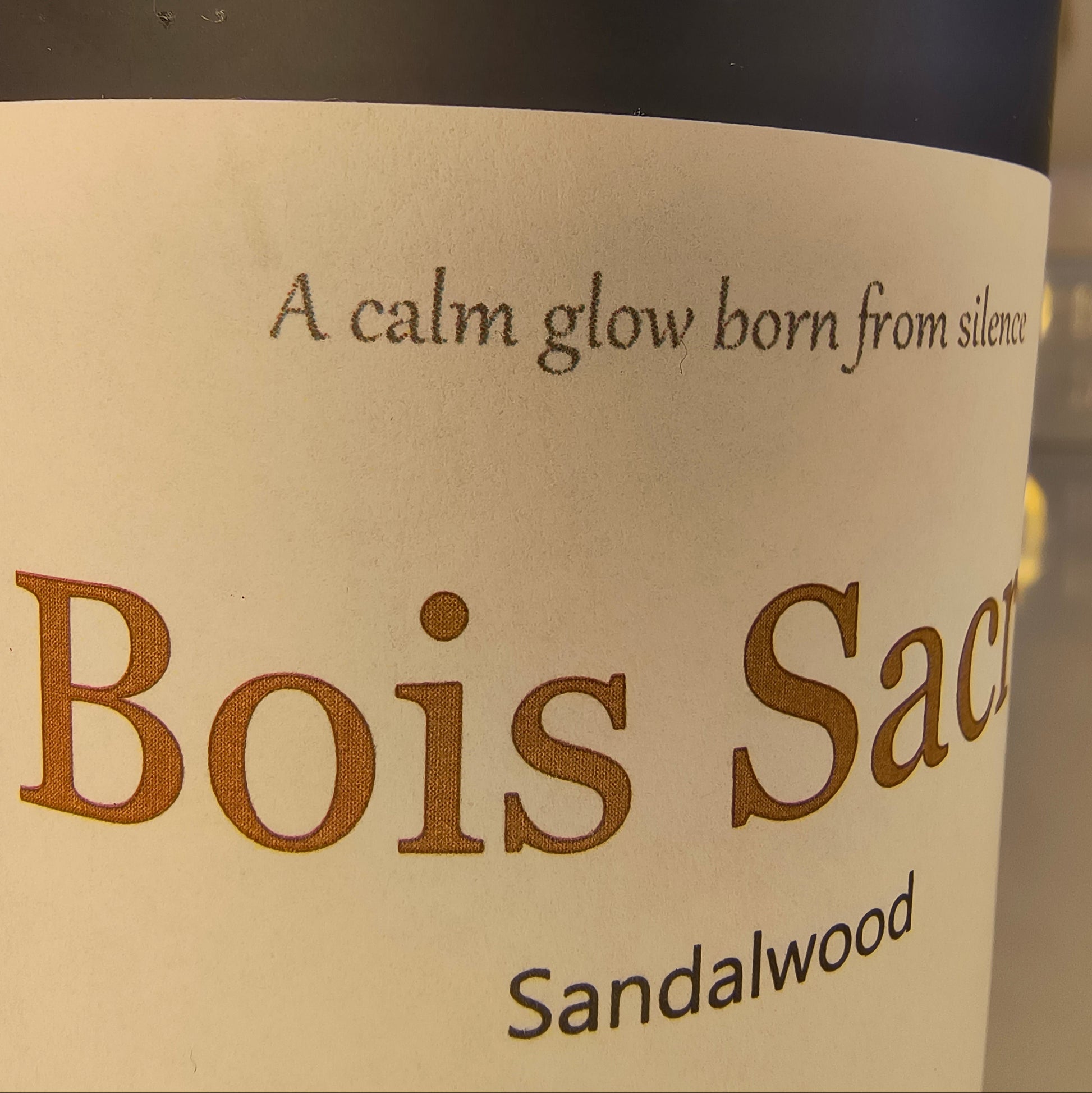 Candle 'Bois Sacre' sandalwood label on a dark background