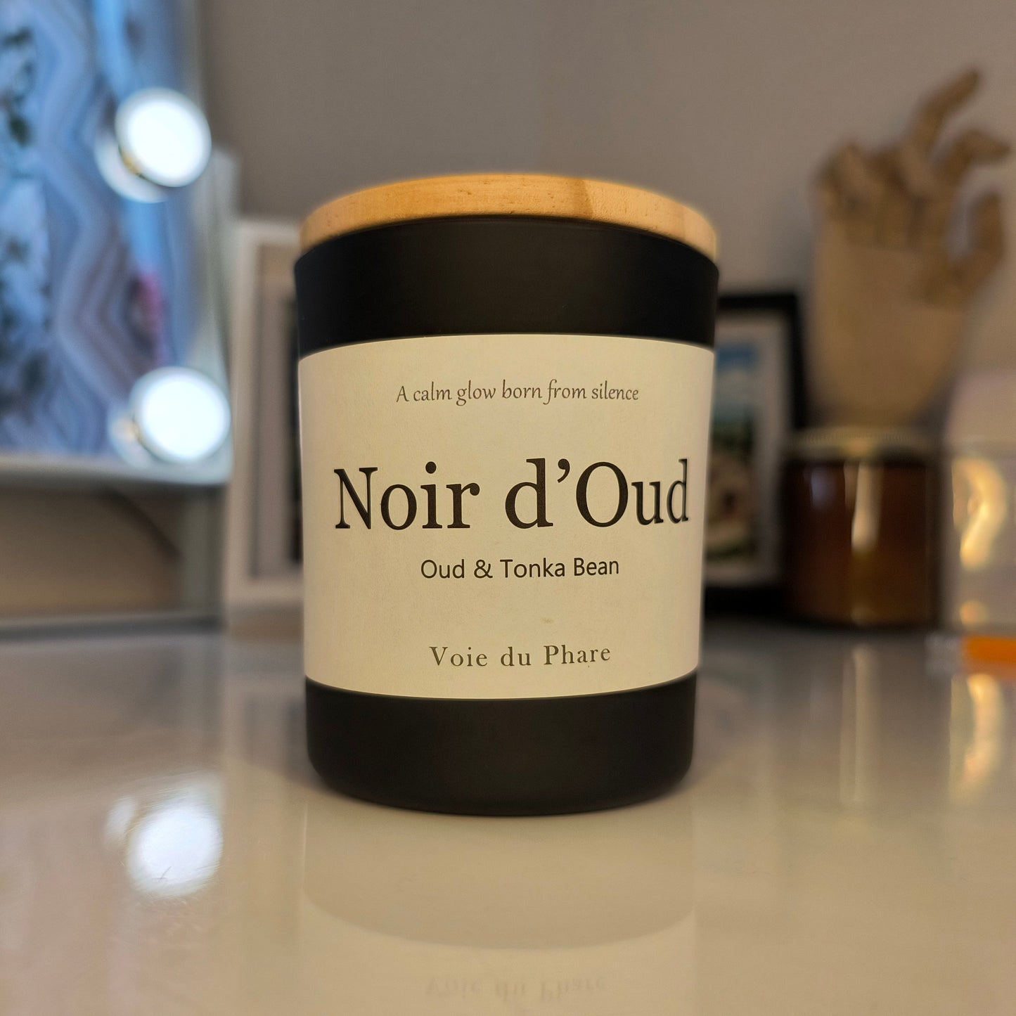 Cylindrical candle container with a label on a reflective surface