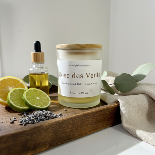 Candle labeled 'Rose des Vents' on a wooden tray with lemons, limes, and lavender.