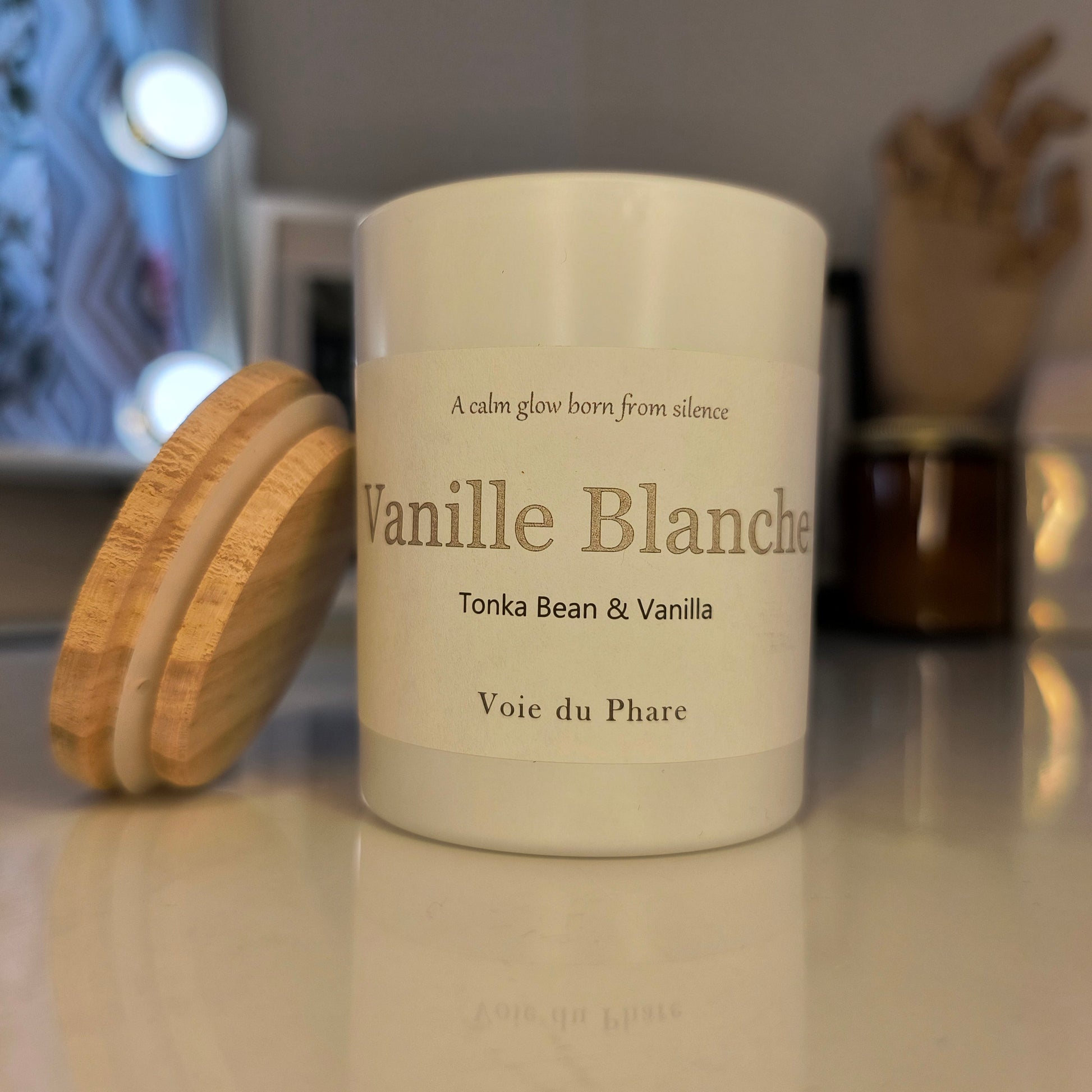 Vanilla scented candle with wooden lid on a white surface